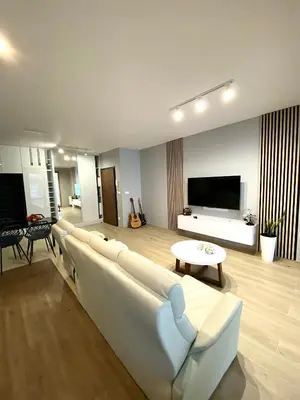 a living room with a white couch and a tv at Mimosa Kraków Apartment in Kraków