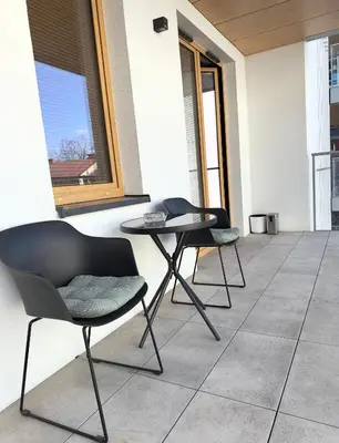 two chairs and a table on a patio at Mimosa Kraków Apartment in Kraków