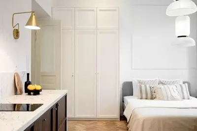 a white kitchen with a bed and a couch at Pędzichów Old Town Apartments in Kraków