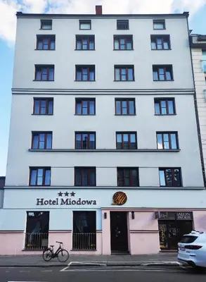 a building with a bike parked in front of it at Hotel Miodowa in Kraków