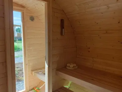 a wooden sauna with a bench in the middle at Glamping Pogorzany - Jurty in Zabierzów