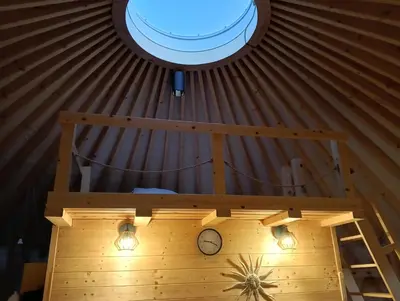 a room with a ceiling with a clock and a window at Glamping Pogorzany - Jurty in Zabierzów
