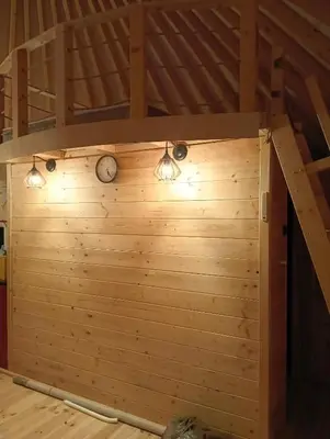a room with a wooden wall with lights on it at Glamping Pogorzany - Jurty in Zabierzów