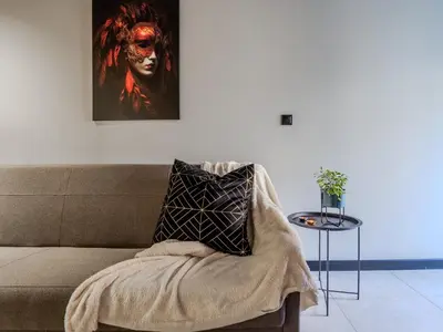a couch with a blanket and a picture on the wall at A charming loft in the heart of KRAKÓW with free parking in Kraków