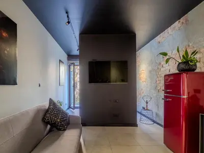 a living room with a couch and a red refrigerator at A charming loft in the heart of KRAKÓW with free parking in Kraków