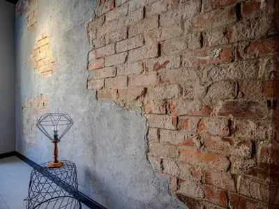 a brick wall with a lamp on a table next to it at A charming loft in the heart of KRAKÓW with free parking in Kraków