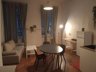 a kitchen and living room with a table and chairs at Apartament Batorego in Kraków