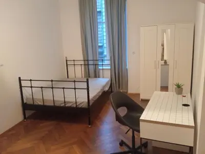 a bedroom with a bed and a desk and a table at Apartament Batorego in Kraków