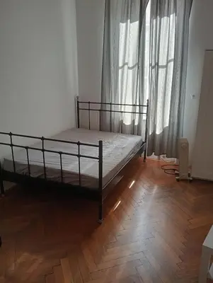 a bed in a room with a wooden floor at Apartament Batorego in Kraków