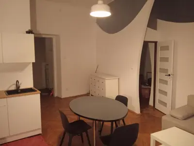 a kitchen and a table and chairs in a room at Apartament Batorego in Kraków