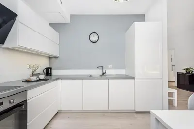 a white kitchen with white cabinets and a sink at Old Town Apartment Browar Lubicz Krakow in Kraków
