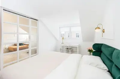 a white room with a bed and a window at Floriańska Old Town Apartments in Kraków