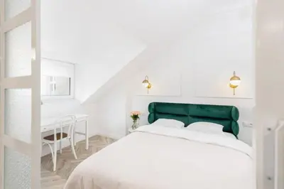 a bedroom with a green and white bed and a desk at Floriańska Old Town Apartments in Kraków