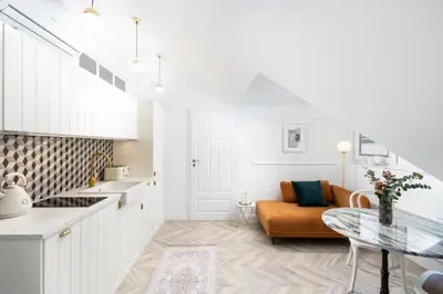 a kitchen and living room with a couch and a table at Floriańska Old Town Apartments in Kraków