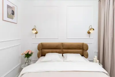 a bedroom with a bed with white sheets and flowers at Floriańska Old Town Apartments in Kraków
