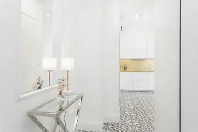 a white room with a glass table and a mirror at Radziwiłłowska Old Town Apartments in Kraków