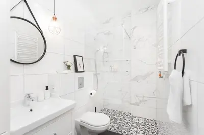 a white bathroom with a shower and a toilet at Radziwiłłowska Old Town Apartments in Kraków