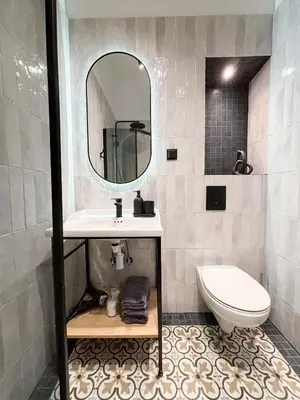 a bathroom with a sink and a toilet and a mirror at LION apartments - PLATINIUM in Kraków