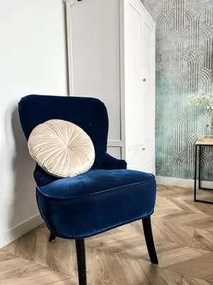 a blue chair with a pillow in a room at LION apartments - PLATINIUM in Kraków
