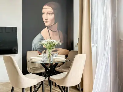 a dining room with a painting of a woman at LION apartments - PLATINIUM in Kraków