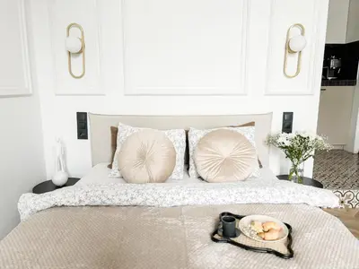 a bed with two pillows and a tray of food on it at LION apartments - PLATINIUM in Kraków