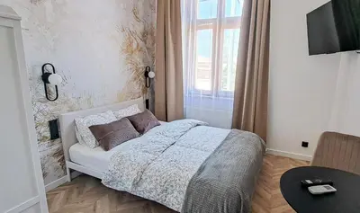 a bedroom with a bed and a window and a table at LION apartments - PLATINIUM in Kraków