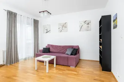 a living room with a purple couch and a table at Borkowska Comfort Apartment by BookingHost in Kraków