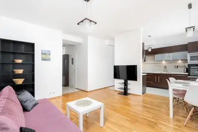 a living room with a purple couch and a table at Borkowska Comfort Apartment by BookingHost in Kraków