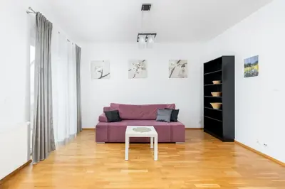 a living room with a purple couch and a table at Borkowska Comfort Apartment by BookingHost in Kraków