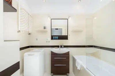 a white bathroom with a sink and a mirror at Borkowska Comfort Apartment by BookingHost in Kraków