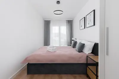a bedroom with a large bed with a pink blanket at Prokocim Kosocicka Apartment by BookingHost in Kraków
