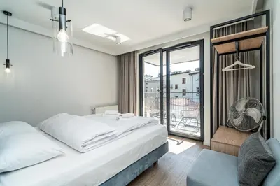 a bedroom with a bed and a large window at RentPlanet - Apartament Dębniki in Kraków