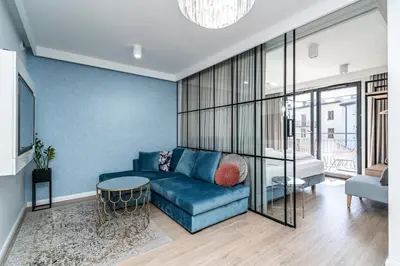 a living room with a blue couch and a table at RentPlanet - Apartament Dębniki in Kraków