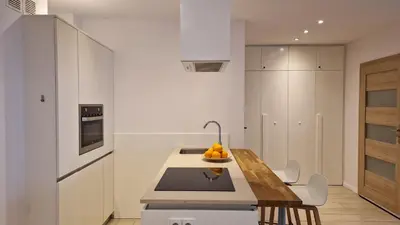 a kitchen with white cabinets and a table with oranges on it at Perfect Location Comfort Apartment City Beat#10 in Kraków