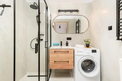 a bathroom with a washing machine and a mirror at Starowiślna 37 Apartment with Mezzanine by BookingHost in Kraków
