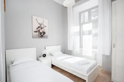 two beds in a bedroom with white walls at Starowiślna 37 Apartment with Mezzanine by BookingHost in Kraków