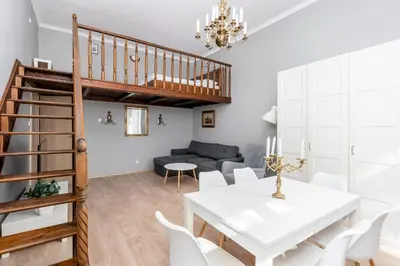 a dining room with a white table and white chairs at Starowiślna 37 Apartment with Mezzanine by BookingHost in Kraków