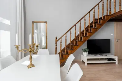 a dining room with a white table and a television at Starowiślna 37 Apartment with Mezzanine by BookingHost in Kraków