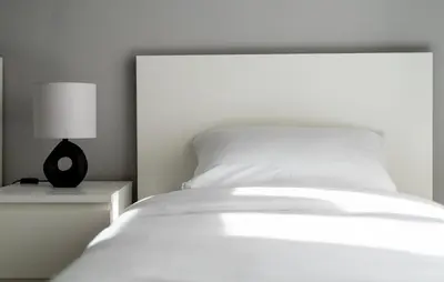 a white bed with a black lamp on a night stand at Starowiślna 37 Apartment with Mezzanine by BookingHost in Kraków