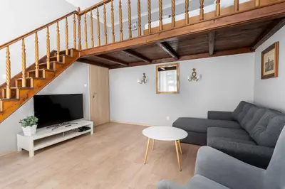 a living room with a couch and a tv at Starowiślna 37 Apartment with Mezzanine by BookingHost in Kraków