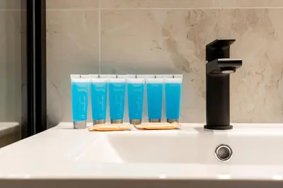 a bathroom sink with a water faucet and blue glasses at Starowiślna 37 Apartment with Mezzanine by BookingHost in Kraków