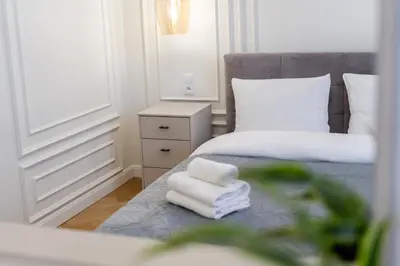 a bedroom with a bed and a mirror and towels at Vistula River Deluxe Apartment by BookingHost in Kraków