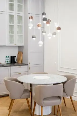 a white kitchen with a white table and chairs at Vistula River Deluxe Apartment by BookingHost in Kraków
