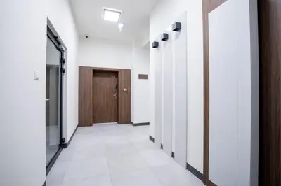 a hallway with white walls and a wooden door at Walerego Sławka Cosy Studio by BookingHost in Kraków