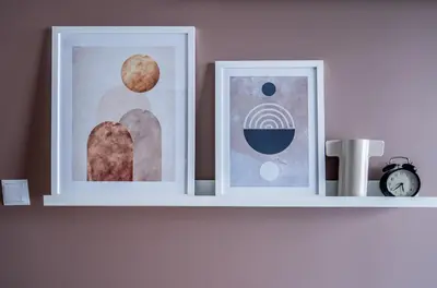 two framed pictures on a shelf with a clock at Walerego Sławka Cosy Studio by BookingHost in Kraków