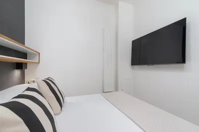 a bedroom with a bed with a television on the wall at Studio Apartment - Dietla 21 street in Kraków