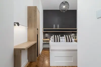 a bedroom with a bed and a desk and a lamp at Studio Apartment - Dietla 21 street in Kraków