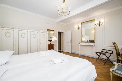 a white bedroom with a large white bed and a mirror at Househost Apt: Starowiślna 75/3/2 in Kraków