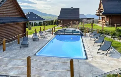a swimming pool in a yard with chairs and a house at Awesome Home In Slopnice With Sauna in Słopnice