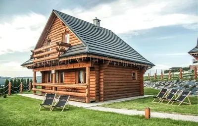 a log cabin with chairs in front of it at Awesome Home In Slopnice With Sauna in Słopnice